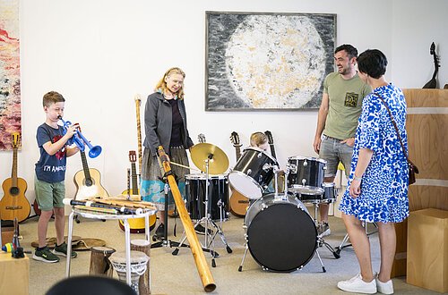 Eine Familie testet während einer Führung im KunstMuseum die Musikinstrumente.