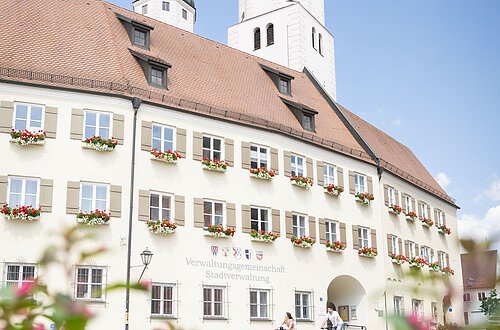 Zwei Radfahrer fahren am Verwaltungsgebäude mit ihrem Fahrrad vorbei.