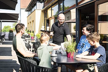 Eine Familie isst auf der Terrasse beim Lieblingsgrieche in Wemding.
