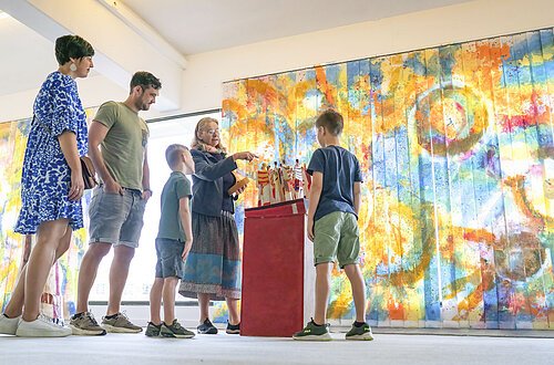 Eine Familie sieht sich im KunstMuseum ein Kunstwerk an.