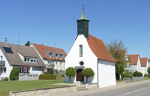 Die Leonhardkapelle vom Straßenrand aus an einen sonnigen Tag.