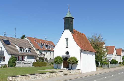Die Leonhardkapelle vom Straßenrand aus an einen sonnigen Tag.