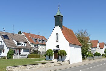 Die Leonhardkapelle vom Straßenrand aus an einen sonnigen Tag.