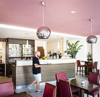 Ein Mann läuft zu den Tischen im Lieblingsgrieche und bedient die Gäste.