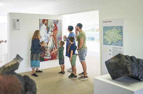 Eine Familie betrachtet ein gemaltes Bild im KunstMuseum Donau-Ries.