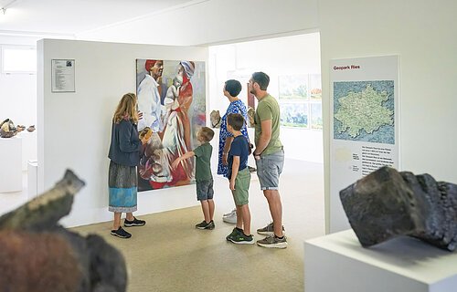 Eine Familie betrachtet ein gemaltes Bild im KunstMuseum Donau-Ries.