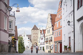 Zwei Radfahrer fahren zusammen in der historischen Altstadt in der Wallfahrtstraße.