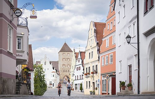Zwei Radfahrer fahren zusammen in der historischen Altstadt in der Wallfahrtstraße.