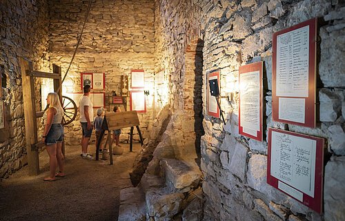 Eine Familie informiert sich im Folterturm Wemding im Rahmen einer Stadtführung mit Besichtigung Folterturm.